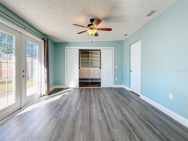 interior space with a textured ceiling, light hardwood / wood-style flooring, and a wealth of natural light