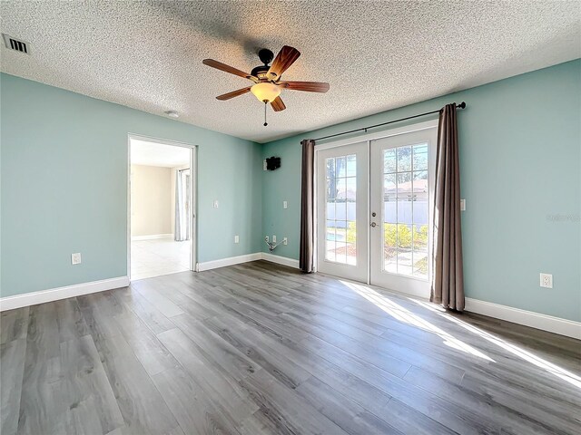 empty room with ceiling fan, wood-type flooring, a textured ceiling, and french doors