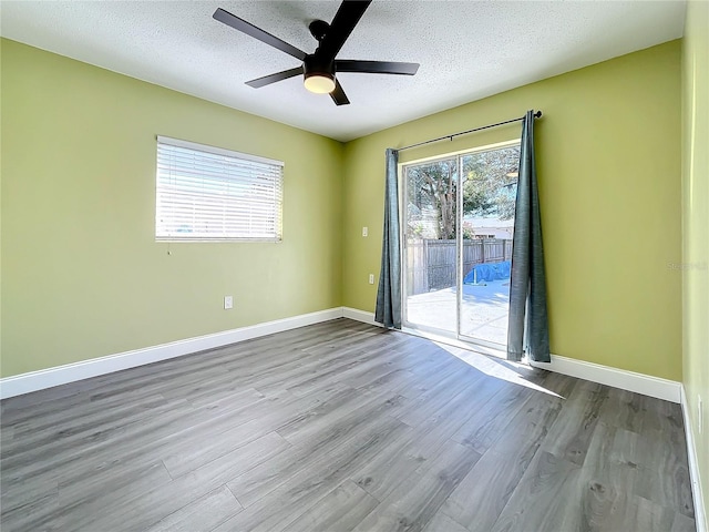 unfurnished room with ceiling fan, light wood-type flooring, and a textured ceiling