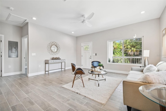 living room featuring ceiling fan, electric panel, and light hardwood / wood-style flooring