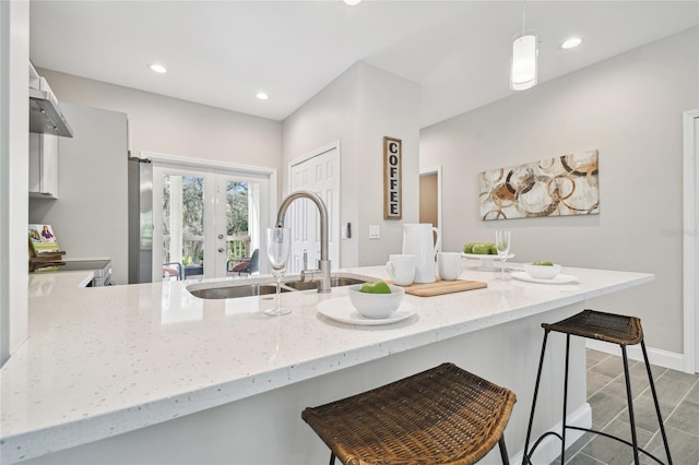 kitchen with sink, kitchen peninsula, extractor fan, decorative light fixtures, and range