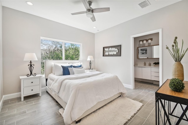 bedroom featuring ceiling fan, light hardwood / wood-style floors, sink, and connected bathroom