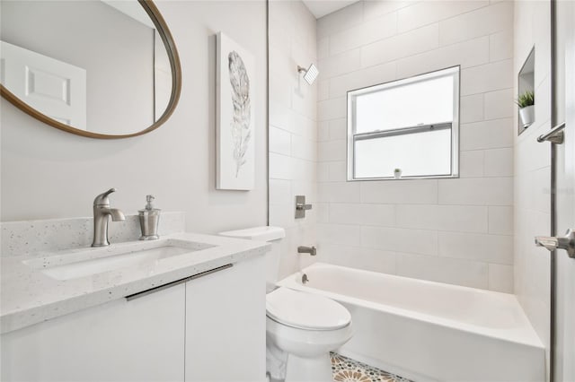 full bathroom featuring vanity, tiled shower / bath combo, and toilet