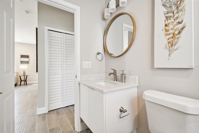 bathroom featuring hardwood / wood-style floors, vanity, and toilet