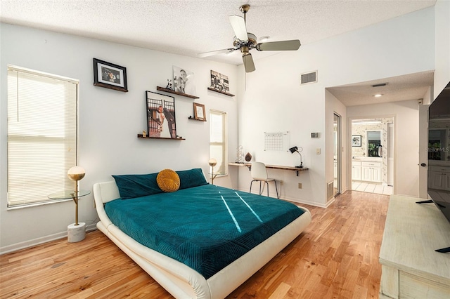 bedroom featuring hardwood / wood-style flooring, ceiling fan, a textured ceiling, and connected bathroom