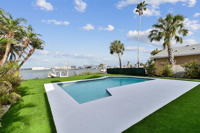 view of pool with a lawn and a water view