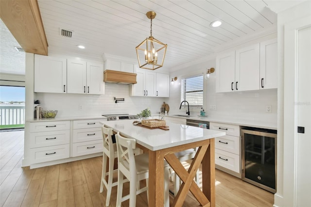 kitchen featuring white cabinets, a wealth of natural light, and beverage cooler