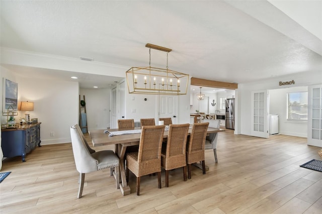 dining space with a chandelier, french doors, and light hardwood / wood-style flooring