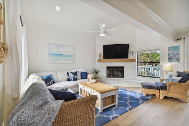 living room featuring hardwood / wood-style flooring, a brick fireplace, ceiling fan, and ornamental molding