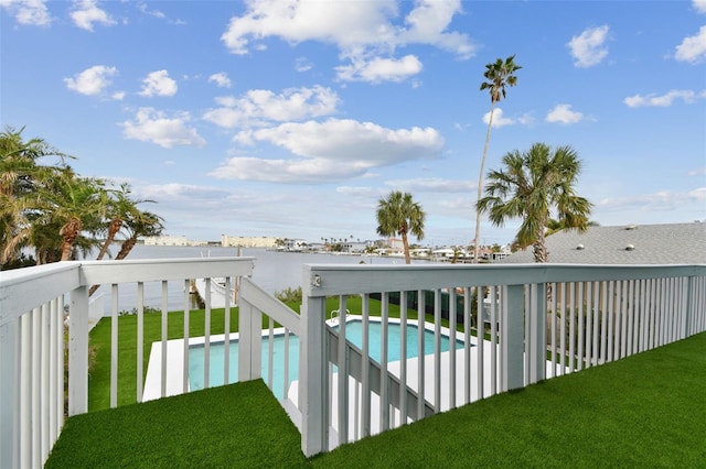 view of swimming pool with a lawn and a water view