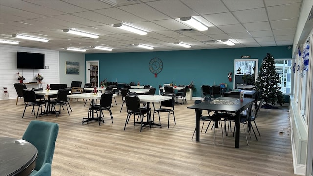 dining area featuring light hardwood / wood-style flooring and a drop ceiling