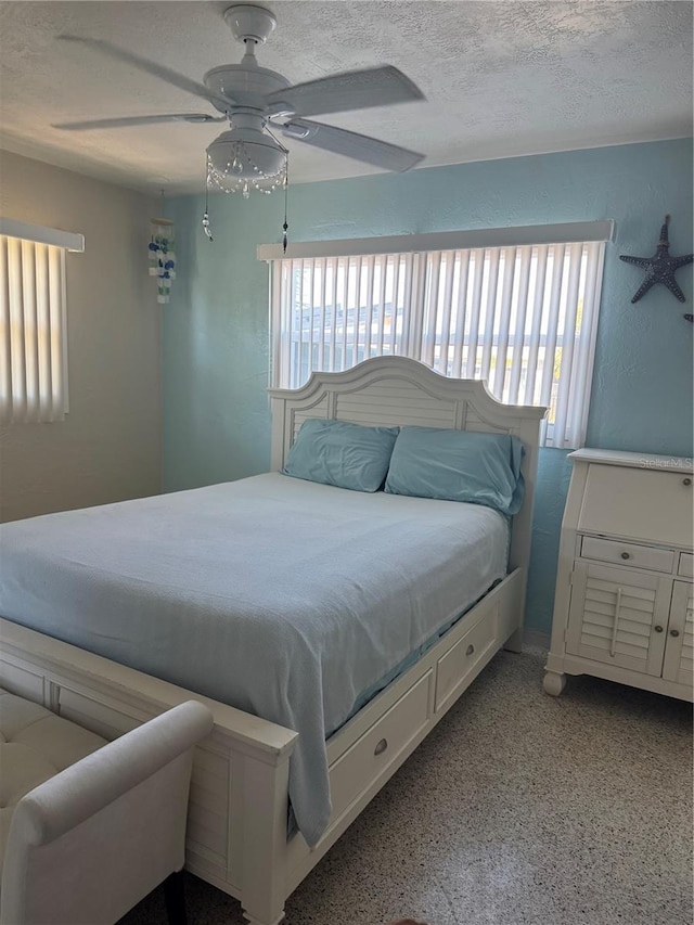 bedroom featuring ceiling fan and a textured ceiling