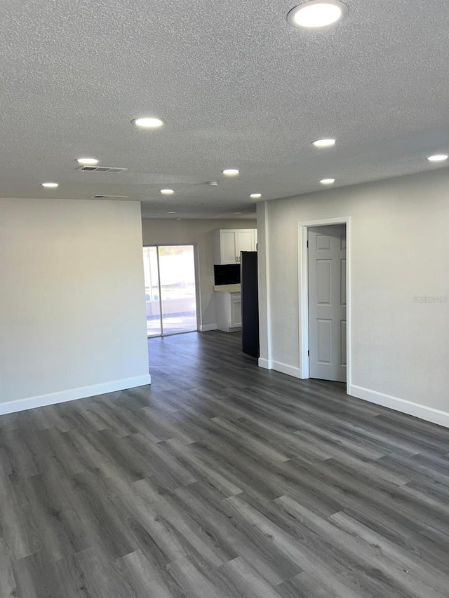 interior space featuring a textured ceiling and dark hardwood / wood-style floors