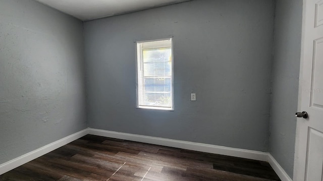 unfurnished room featuring dark wood-type flooring