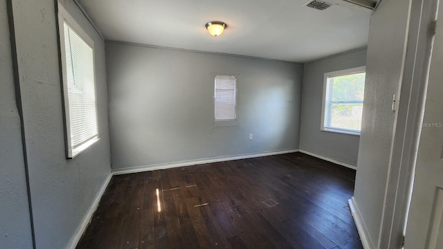 unfurnished room featuring dark wood-type flooring and ornamental molding