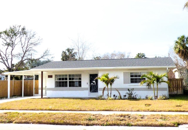 ranch-style home featuring a front yard and a carport