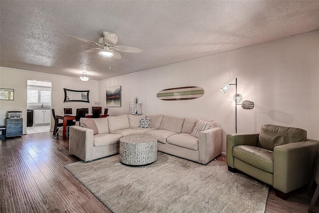 living room with ceiling fan, wood-type flooring, and a textured ceiling