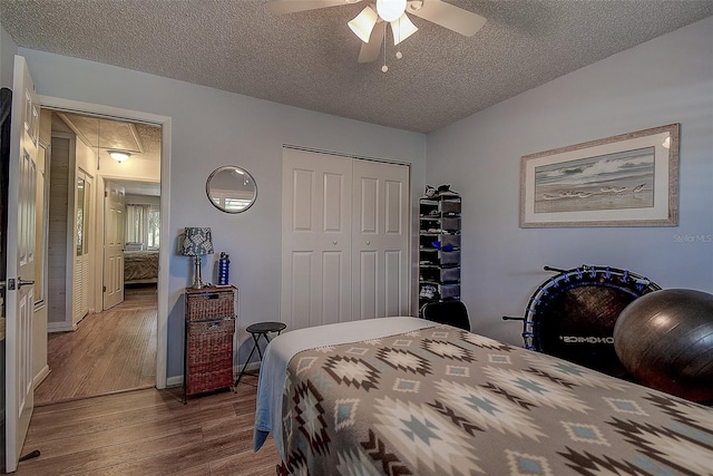 bedroom featuring hardwood / wood-style flooring, ceiling fan, a textured ceiling, and a closet