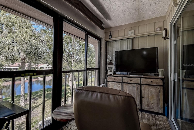 sunroom / solarium featuring a water view