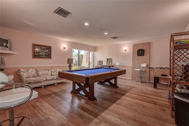 rec room featuring wooden walls, billiards, a textured ceiling, and hardwood / wood-style flooring