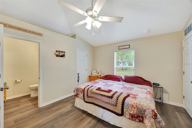 bedroom with hardwood / wood-style floors, lofted ceiling, ensuite bathroom, ceiling fan, and a textured ceiling