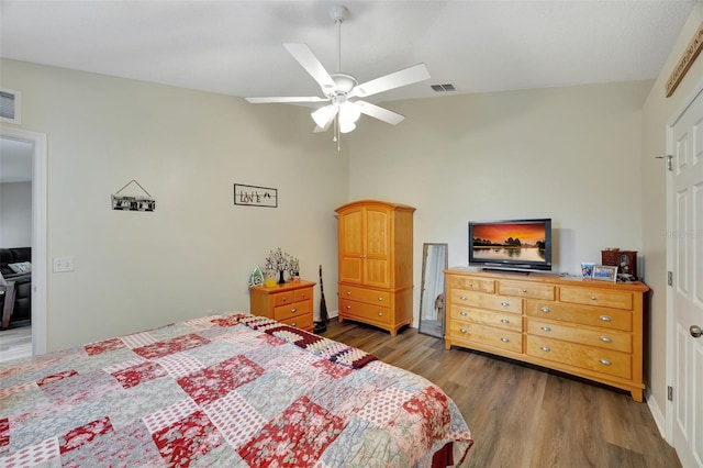 bedroom featuring dark hardwood / wood-style floors, ceiling fan, and lofted ceiling