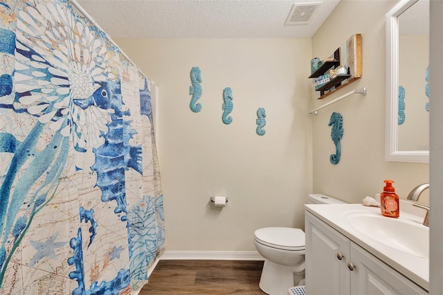 bathroom featuring curtained shower, a textured ceiling, toilet, vanity, and hardwood / wood-style flooring