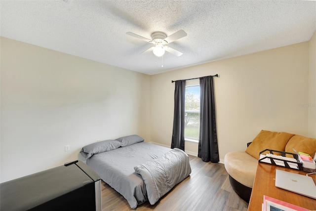 bedroom featuring ceiling fan, a textured ceiling, and hardwood / wood-style flooring