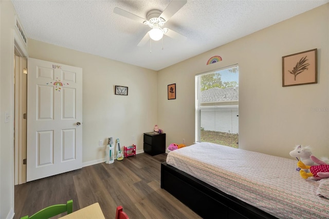 bedroom featuring a textured ceiling, ceiling fan, and dark wood-type flooring