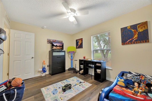 bedroom featuring a textured ceiling, dark hardwood / wood-style floors, and ceiling fan