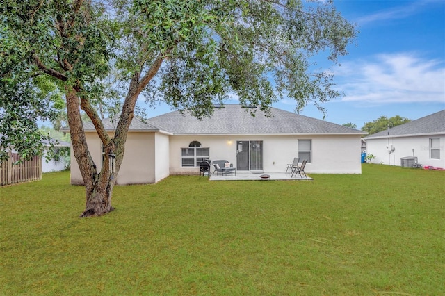 rear view of property with central AC unit, a yard, and a patio