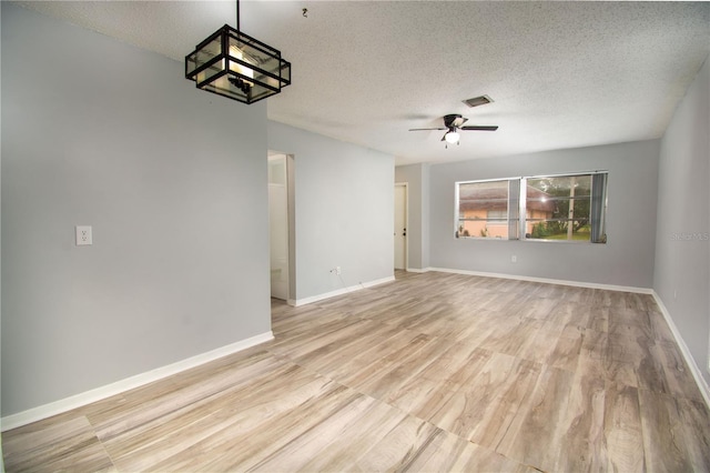 unfurnished room with ceiling fan, a textured ceiling, and light hardwood / wood-style flooring