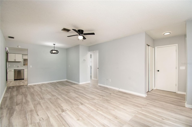 unfurnished living room with ceiling fan, a textured ceiling, and light wood-type flooring