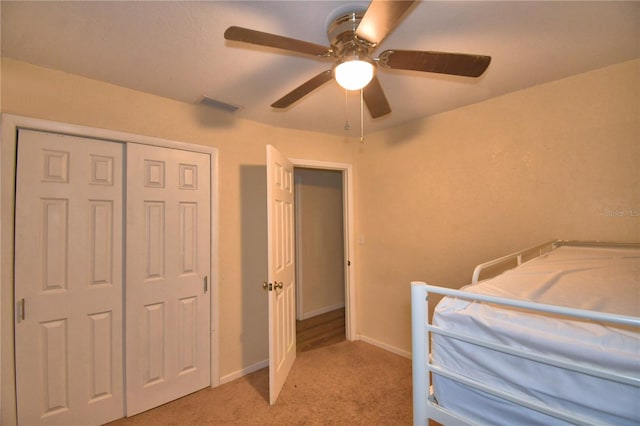 carpeted bedroom featuring a closet and ceiling fan