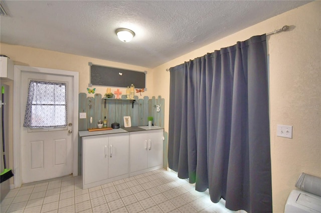 kitchen with a textured ceiling and light tile patterned flooring