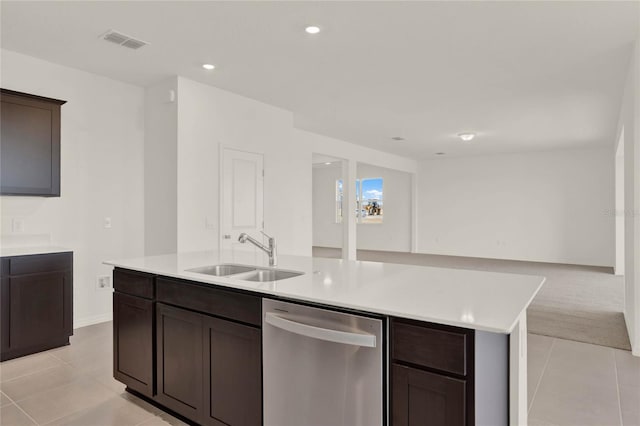 kitchen featuring sink, stainless steel dishwasher, light tile patterned floors, an island with sink, and dark brown cabinets