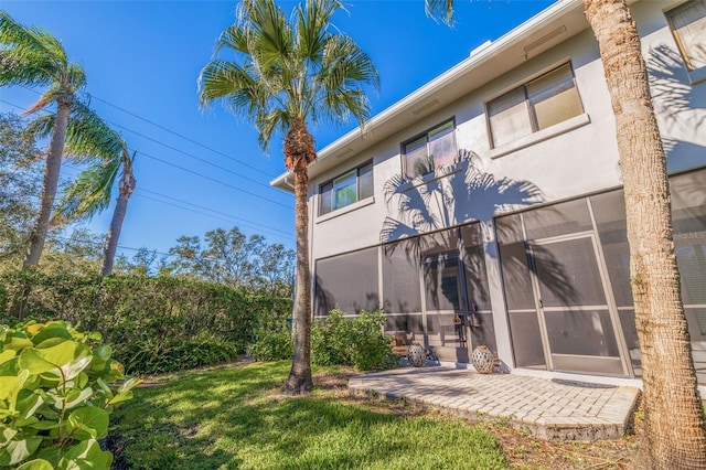 rear view of property with a yard and a patio area