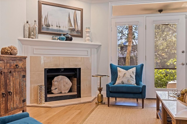 living area featuring a healthy amount of sunlight, a premium fireplace, and wood finished floors
