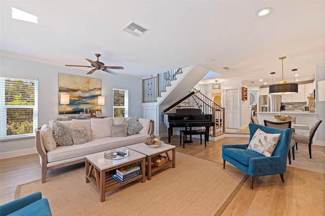 living room with visible vents, stairs, ceiling fan, recessed lighting, and light wood-type flooring