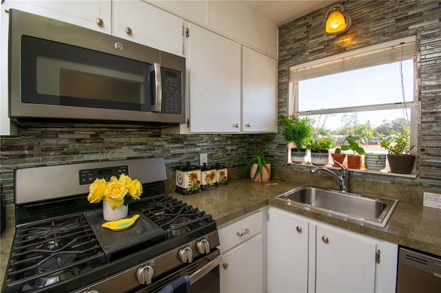 kitchen with decorative backsplash, sink, white cabinets, and appliances with stainless steel finishes