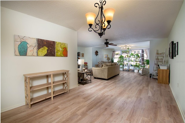 living room with a textured ceiling, ceiling fan with notable chandelier, and hardwood / wood-style flooring