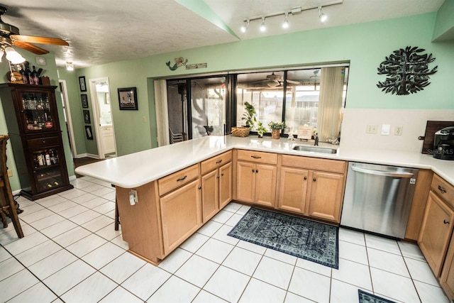 kitchen with stainless steel dishwasher, ceiling fan, light tile patterned floors, a textured ceiling, and kitchen peninsula