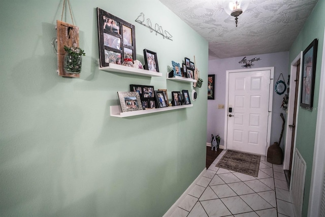 doorway featuring a textured ceiling and tile patterned floors