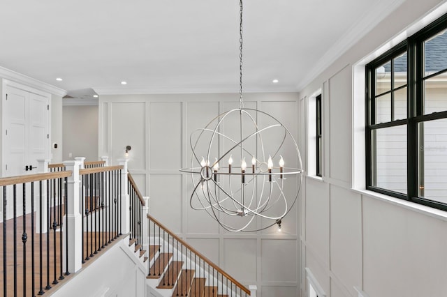 stairs featuring ornamental molding and a chandelier