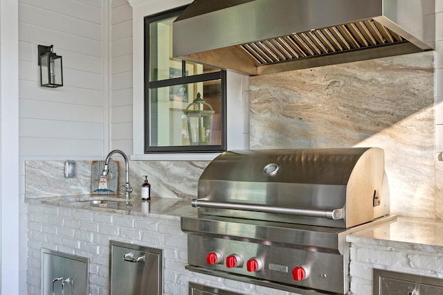 exterior space featuring sink and wall chimney range hood