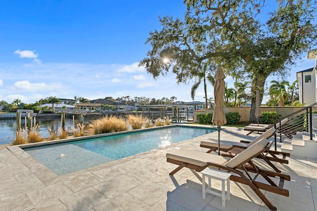 view of swimming pool with a patio area and a water view