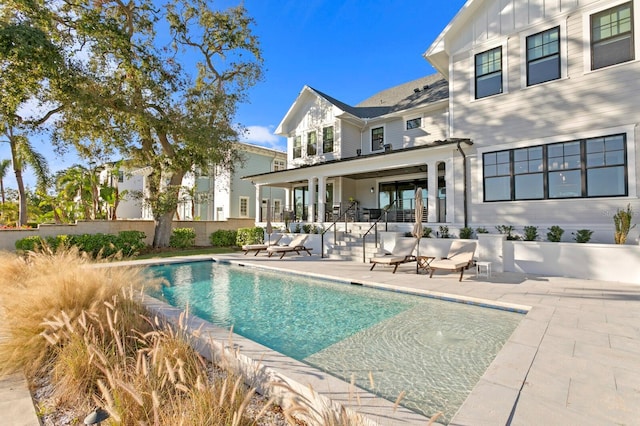 back of house with a fenced in pool and a patio