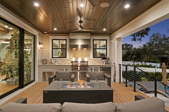 exterior space with sink, a grill, an outdoor kitchen, and a fire pit