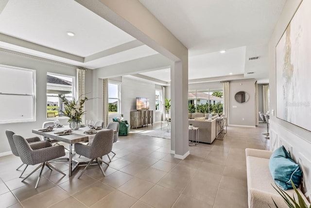 tiled dining room with a tray ceiling