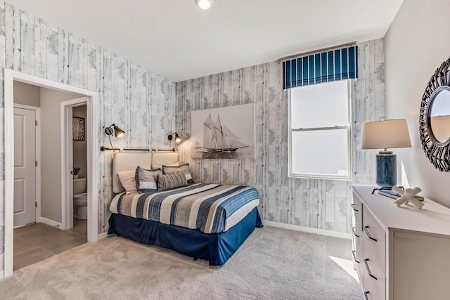 bedroom with connected bathroom, multiple windows, and light colored carpet